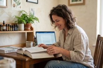 Femme lisant un livre de naturopathie à son bureau à la maison