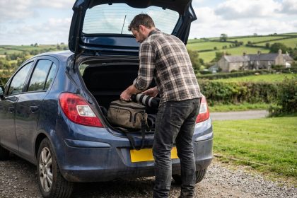 Homme en flanelle d&eacute;ballant un &eacute;quipement photo en campagne